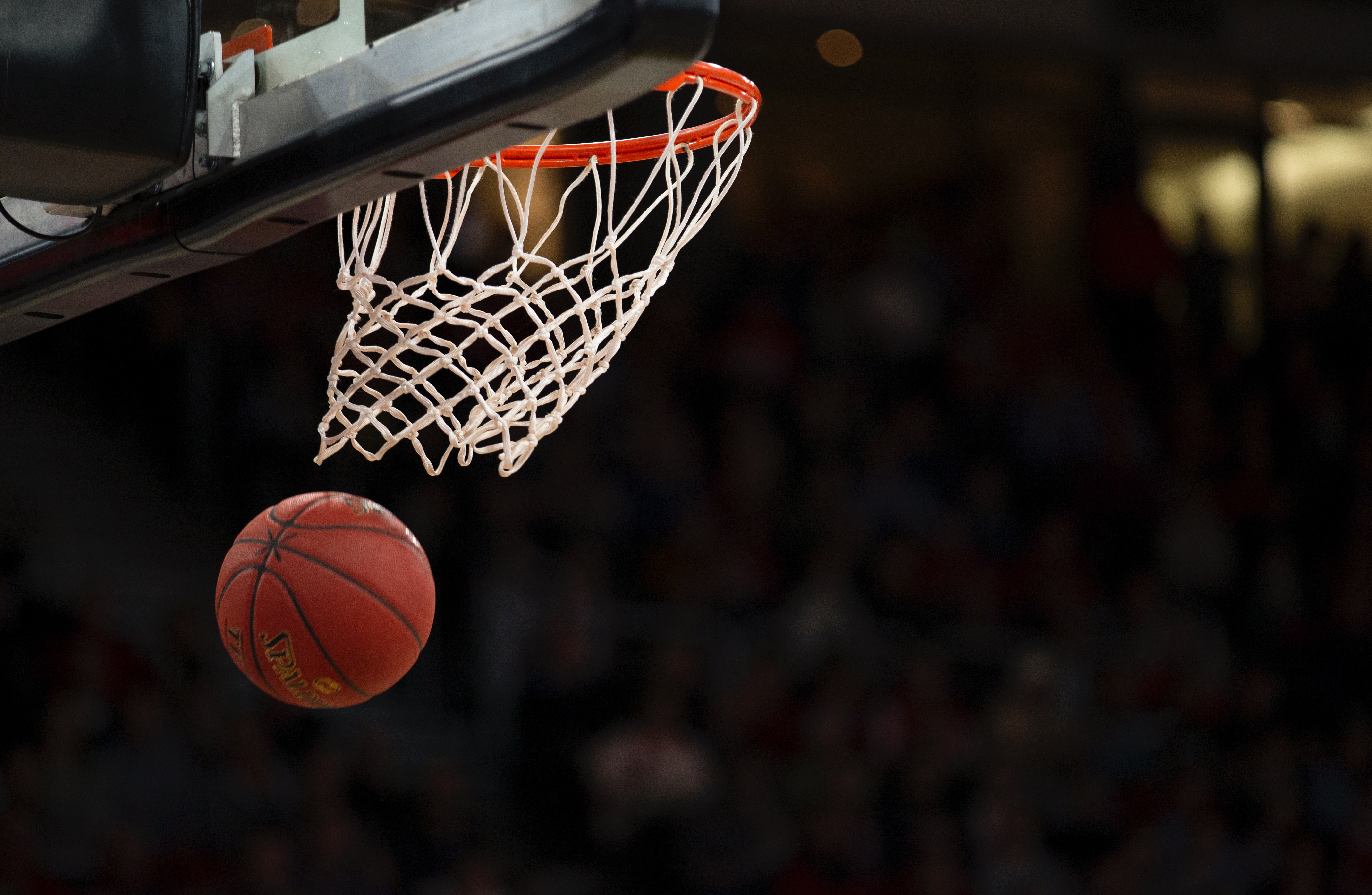 NBA basketball being thrown into a basketball hoop